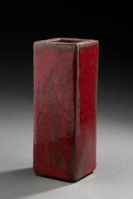 un vase rouge posé sur une table