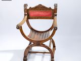 a wooden chair with a red seat on a white background
