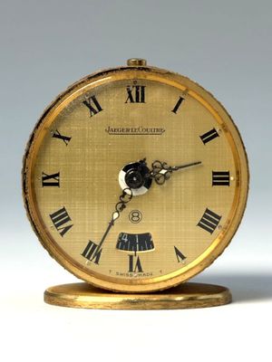 une horloge en or avec des chiffres romains sur le cadran