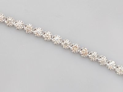 a close up of a diamond bracelet on a gray surface
