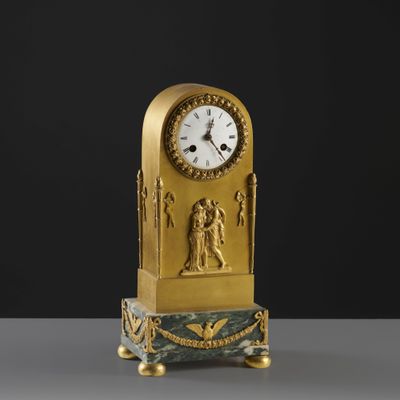 a gold clock sitting on top of a marble table