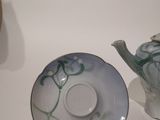 three teapots and a tea cup on a white table