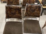 Plusieurs chaises sont alignées dans une pièce où se trouvent un canapé et une table basse