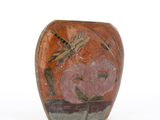 a vase with a dragonfly on it sitting on a table