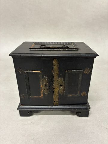Petit cabinet à poser en bois noirci ouvrant à deux portes dévoil
