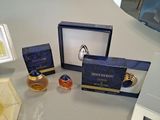 three perfume bottles and a ring on a table