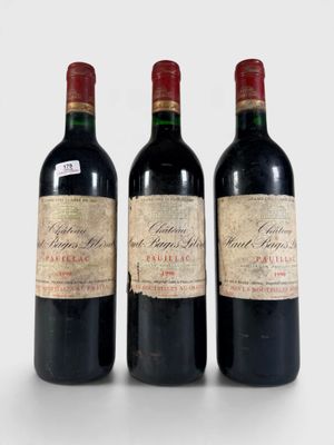 trois bouteilles de vin rouge posées l'une à côté de l'autre sur une surface blanche