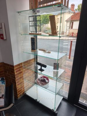 une vitrine en verre dans le coin d'une pièce