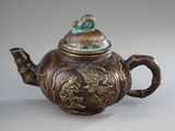 a brown teapot with a dragon design on it