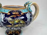 a blue and yellow vase with a lizard on it