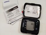 a black cell phone sitting on a table next to a packet of paper