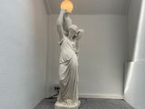 a statue of a woman holding a light in her hand