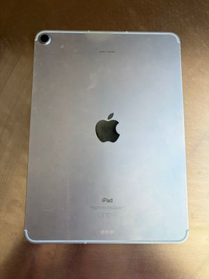 an apple ipad sitting on top of a wooden table next to a cup of coffee