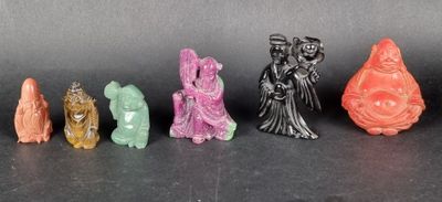 six small figurines of different colors and sizes on a black surface