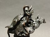 bronze statue of a mermaid holding a fish and a bird