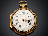 a gold pocket watch with roman numerals on the face