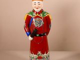 une figurine représentant un homme vêtu d'un costume rouge et d'un chapeau