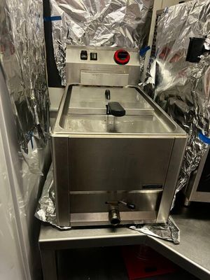 un poêle argenté posé dans une pièce dont les murs sont recouverts de papier d'aluminium
