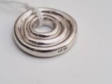 silver plated necklace with a spiral design on a white surface