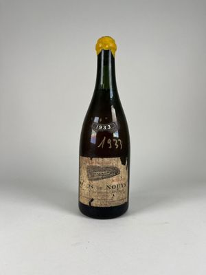une vieille bouteille de vin posée sur une table, sur fond blanc