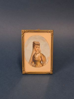 une vieille photo d'une femme dans un cadre doré sur fond bleu