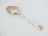 a silver spoon with a spoon handle on a white surface