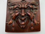 a plaque with a face on it on a wall