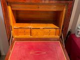 a small wooden desk with a red cloth on it