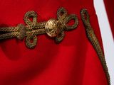 close up of a red dress with gold buttons and a gold belt