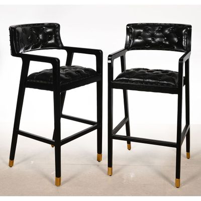 une paire de tabourets de bar en cuir noir aux pieds dorés