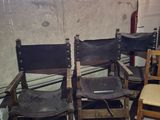 four chairs in a room with a refrigerator in the background