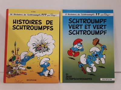 Deux livres sur les Schtroumpfs et les Schtroumpfettes sont posés sur une table