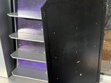 une armoire noire avec des étagères violettes devant une fenêtre