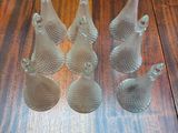 five glass fish figurines sitting on a wooden table