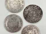 quatre types différents de pièces d'argent sur une surface blanche