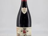 a bottle of red wine sitting on top of a white table