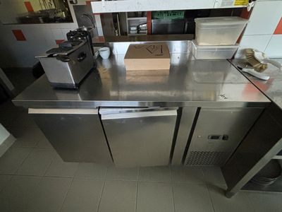 plan de travail en acier inoxydable dans une cuisine professionnelle, sur lequel est posé un bac
