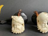 three figurines of animals and a pipe on a table