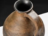 a large brown vase sitting on a white surface