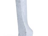 a white stone sculpture of a boot on a white surface
