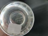 someone is holding a glass with a piece of paper in it