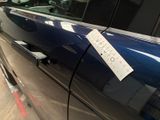 a sticker on the door of a car that is parked in a parking lot