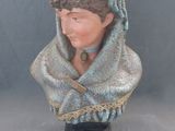 statue d'une femme portant un foulard sur la tête, posée sur un socle
