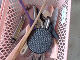 a pink basket filled with different types of kitchen utensils