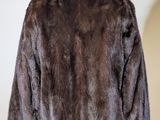 the back of a brown fur jacket on a mannequin stand