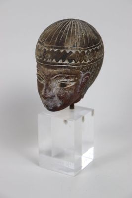 une photo représentant une statue représentant une tête posée sur un socle transparent
