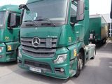 plusieurs camions verts garés les uns à côté des autres sur un parking