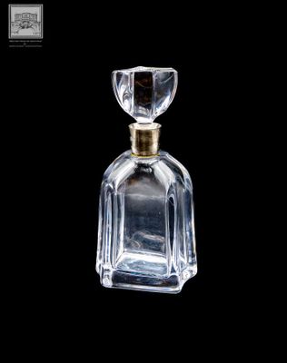 flacon de parfum en verre transparent avec un bouchon doré, sur fond noir