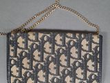 a black and beige purse with a chain hanging from it