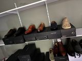 many pairs of shoes on the shelves in the closet